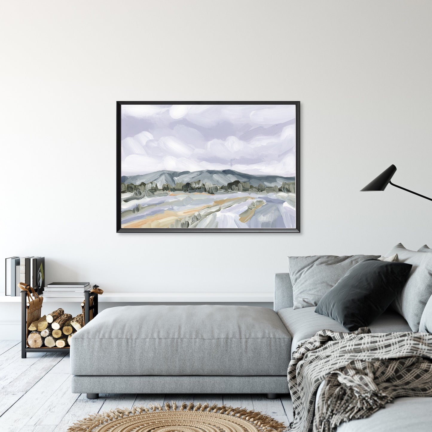 Framed landscape painting depicting mountains and fields under a cloudy sky.