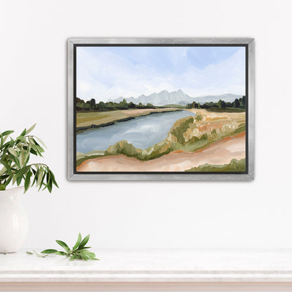 Framed landscape painting depicting a river winding through grassy banks with mountains in the distance.