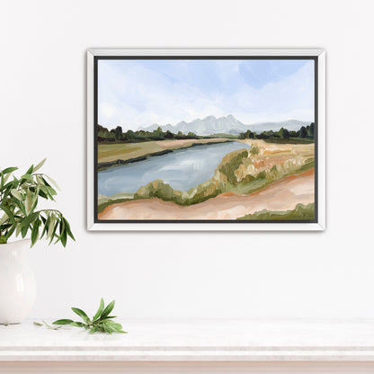 Framed landscape painting depicting a river flowing through countryside with mountains in the distance.