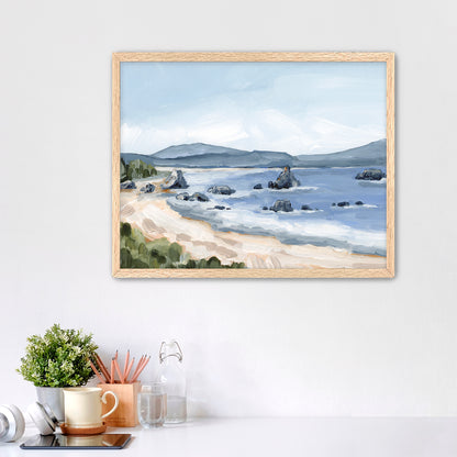 Framed landscape painting of a coastal scene with a beach, water, and distant hills.