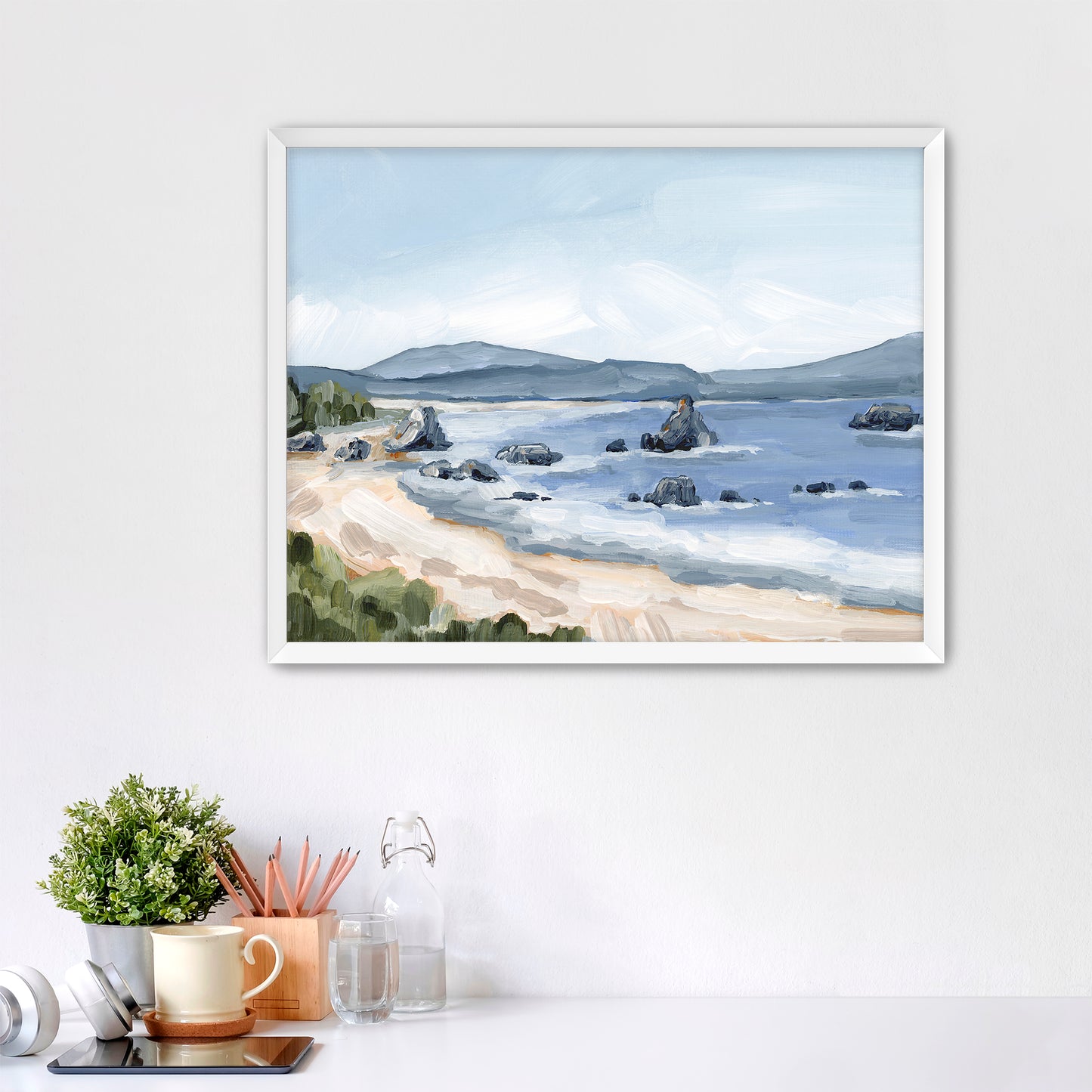 Framed watercolor painting of a coastal seascape with mountains in the distance.